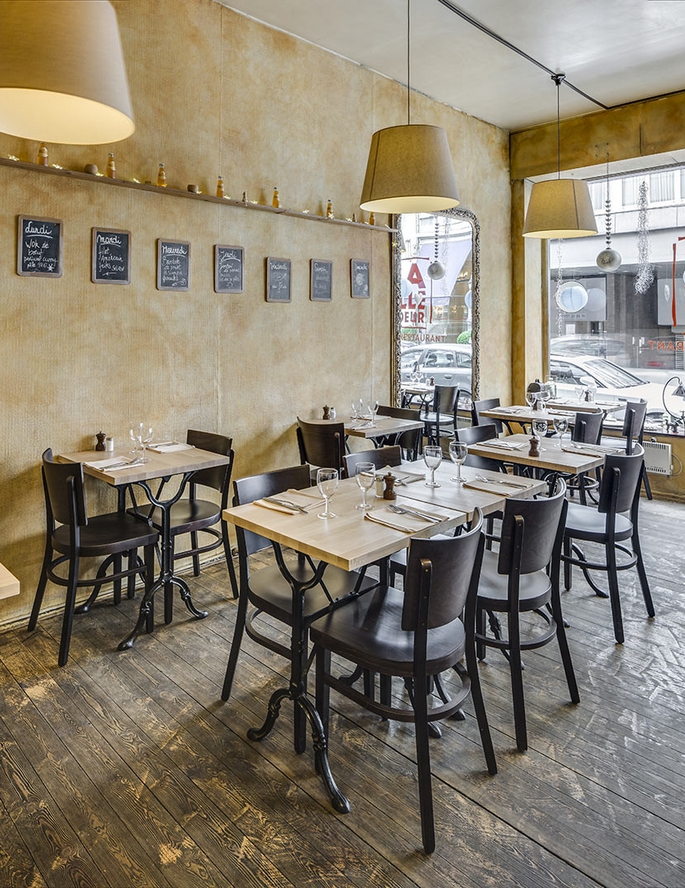 Tables de restaurant carrées en bois massif alignées le long d’une banquette